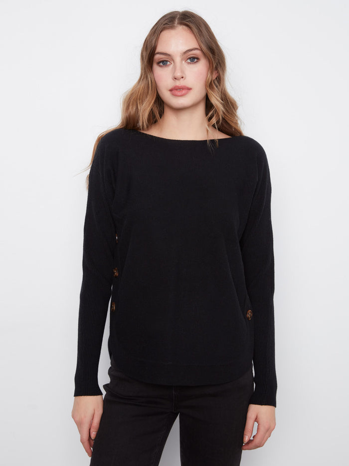 Black sweater with a boat neck and rounded hem, featuring elegant side button details by Charlie B.