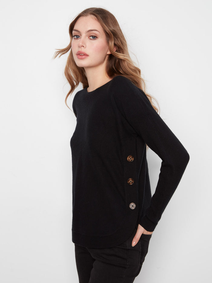 Stylish black sweater showcasing ribbed sleeves and side buttons for added flair by Charlie B.