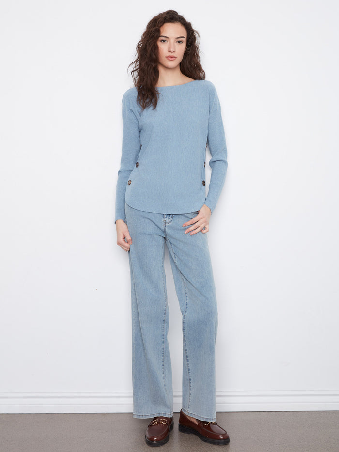 Casual light blue sweater showcasing ribbed sleeves and subtle button accents on the sides by Charlie B.