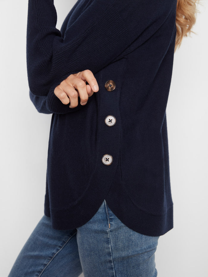 Close-up of the navy sweater's side button details, adding a unique touch to this cozy piece by Charlie B.