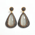 Cima stone pendant earrings featuring rhinestones with teardrop shape and gold plating, adding elegance to any outfit.