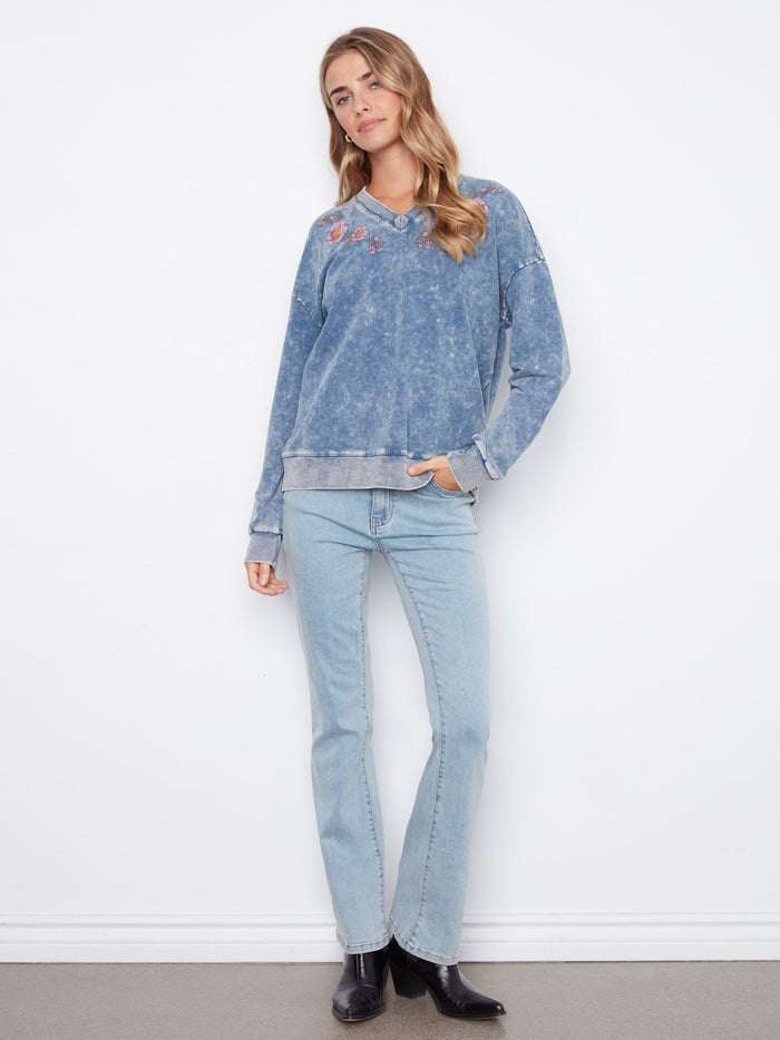 Denim blue V-neck terry top combining comfort and elegance with embroidered floral patterns by Charlie B.