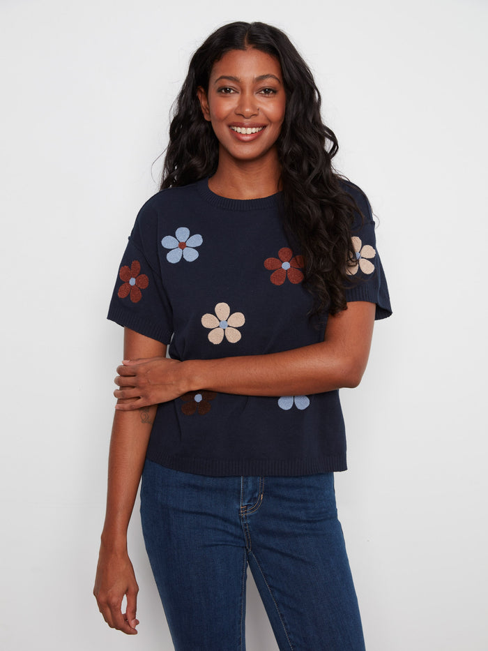 Elegant navy blouse with elbow-length sleeves and a charming floral motif on soft cotton. By Charlie B.