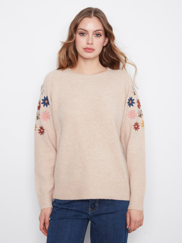 This sweater features a soft knit blend with beautiful floral embroidery along the sleeves, offering a cozy yet stylish look by Charlie B.