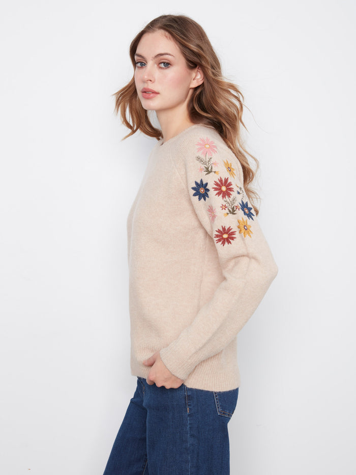 Crafted from a soft knit blend, this sweater is perfect for layering on chilly days, complete with vibrant floral accents by Charlie B.