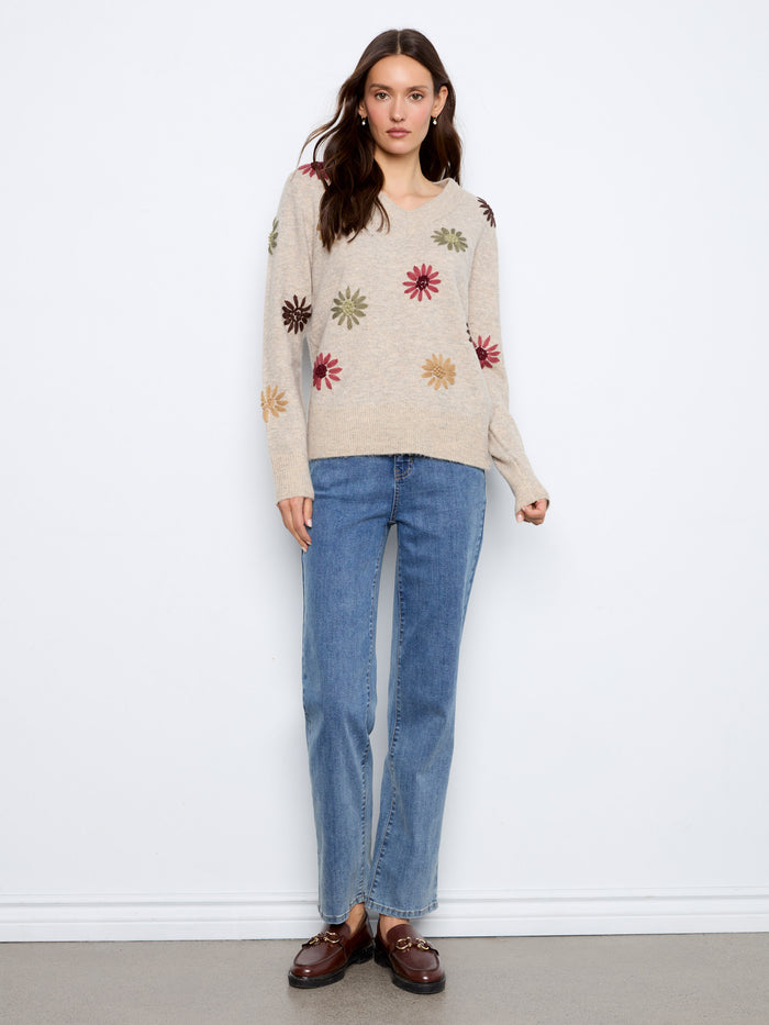 This sweater boasts long sleeves and intricate floral embroidery, perfect for the cooler seasons. By Charlie B.