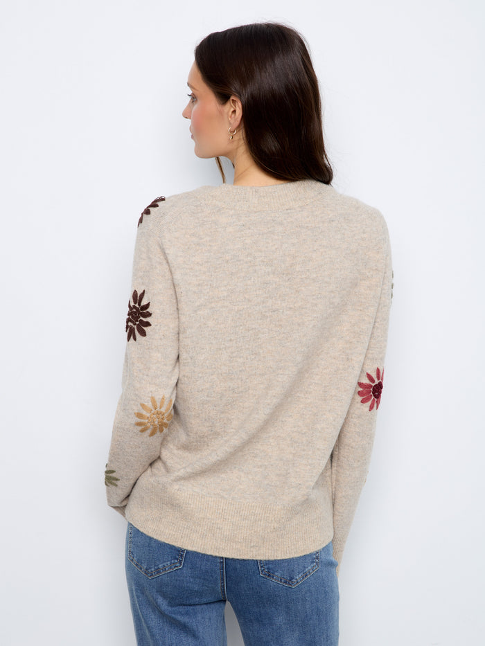 With its classic V-neck and delicate floral details, this sweater is a versatile wardrobe staple. Made by Charlie B.