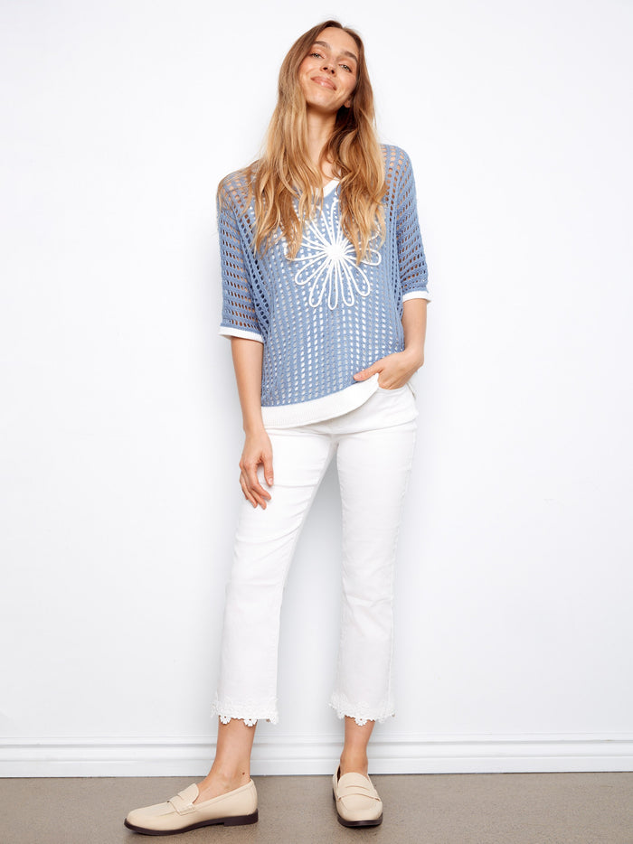 Chic blue top featuring elbow dolman sleeves and intricate floral appliqué for a unique touch. Styled by Charlie B.