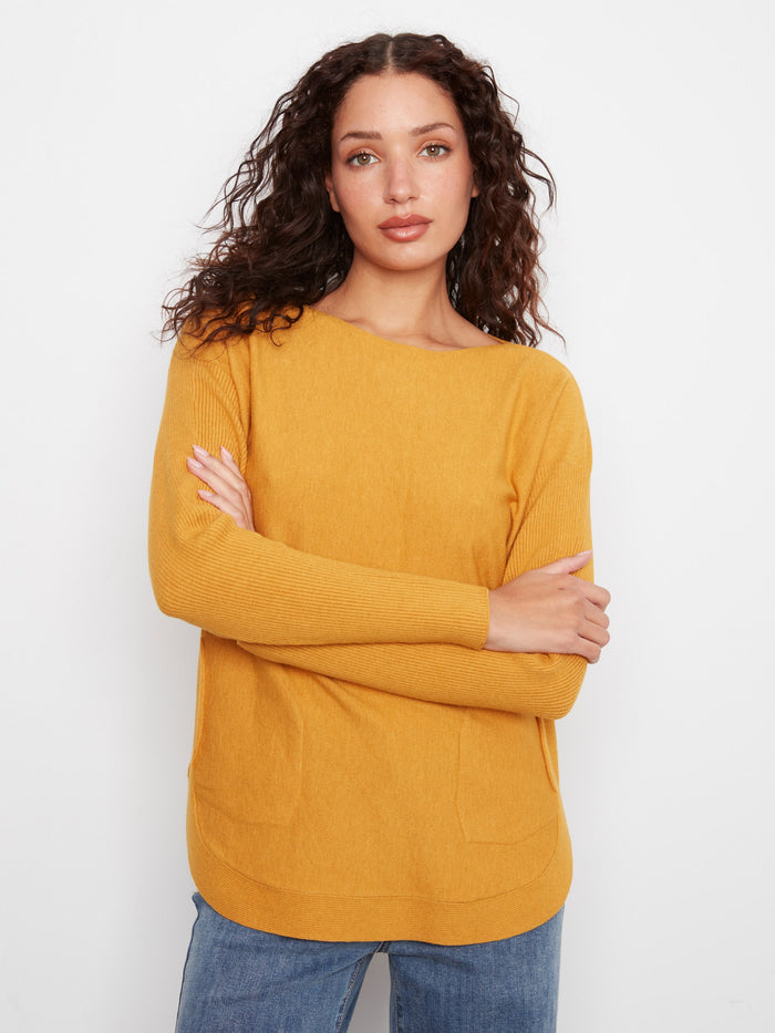 This sweater includes practical poches avant, blending functionality with fashion effortlessly by Charlie B.