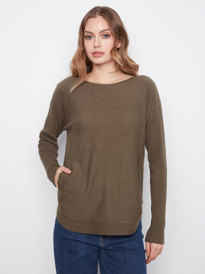 With its rounded hem, this olive sweater offers a flattering silhouette that pairs well with jeans or skirts. By Charlie B.