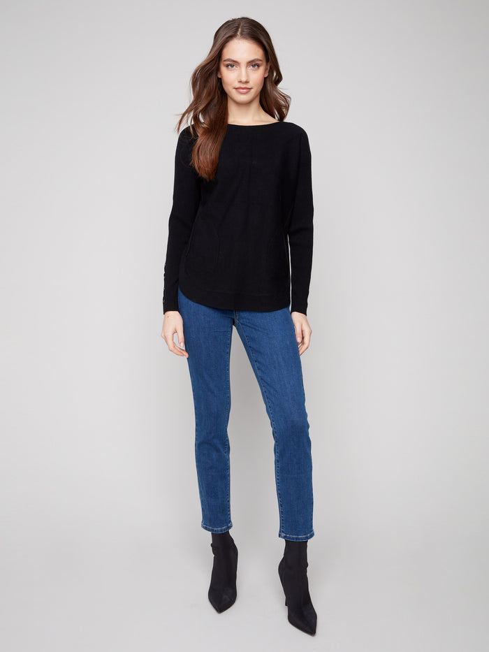 Chic black knit sweater designed with convenient side pockets and rounded hem for everyday practicality by Charlie B.