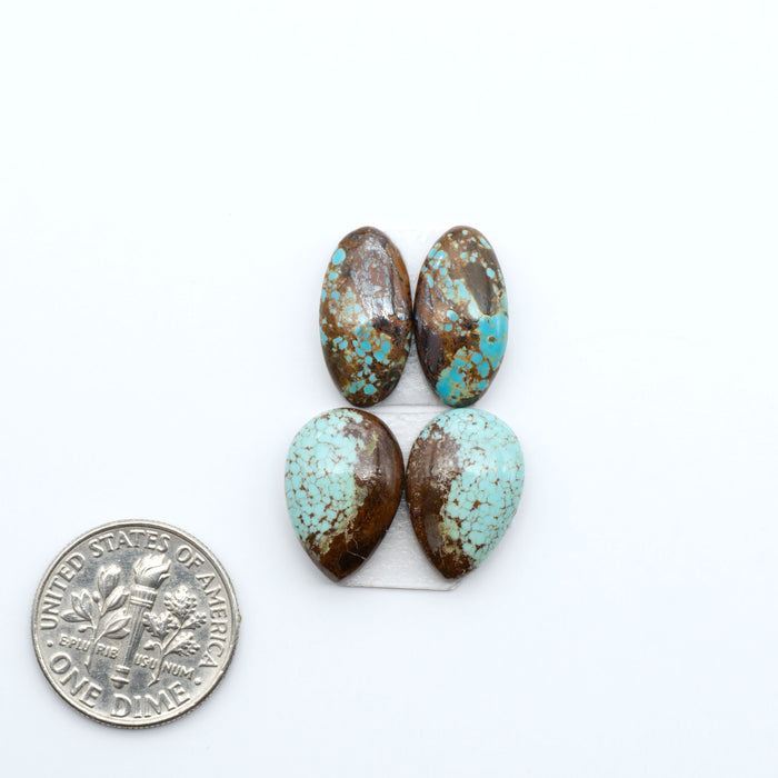 Number 8 Turquoise cabochons, blue and green color with brown matrix, polished stones on a white background, with a US dime for scale