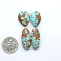 Number 8 Turquoise cabochons, blue and green color with brown matrix, polished stones on a white background, with a US dime for scale