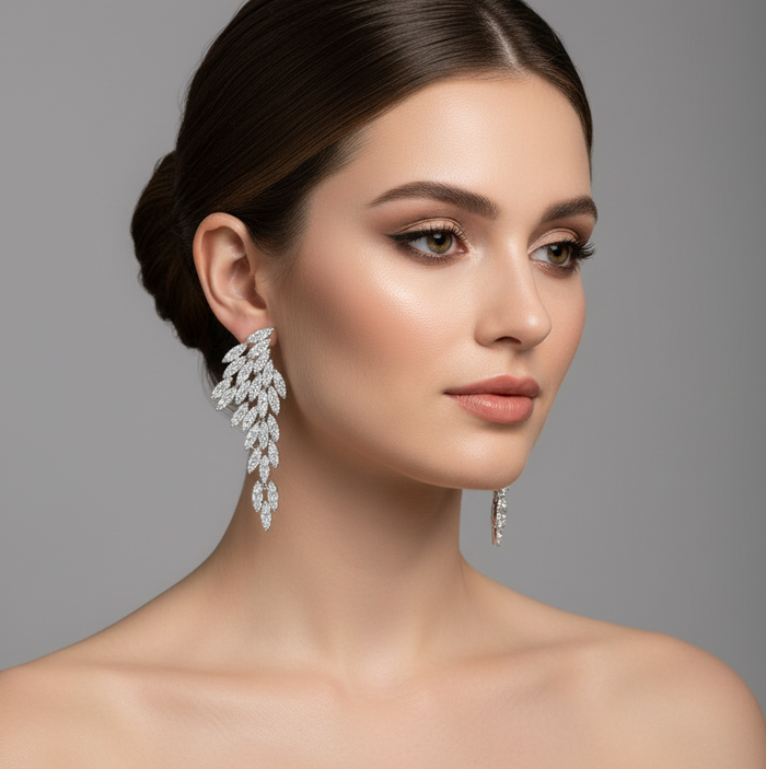 Woman wearing Nysa feather earrings with cubic zirconia crystal leaf petals, showcasing elegance and style.