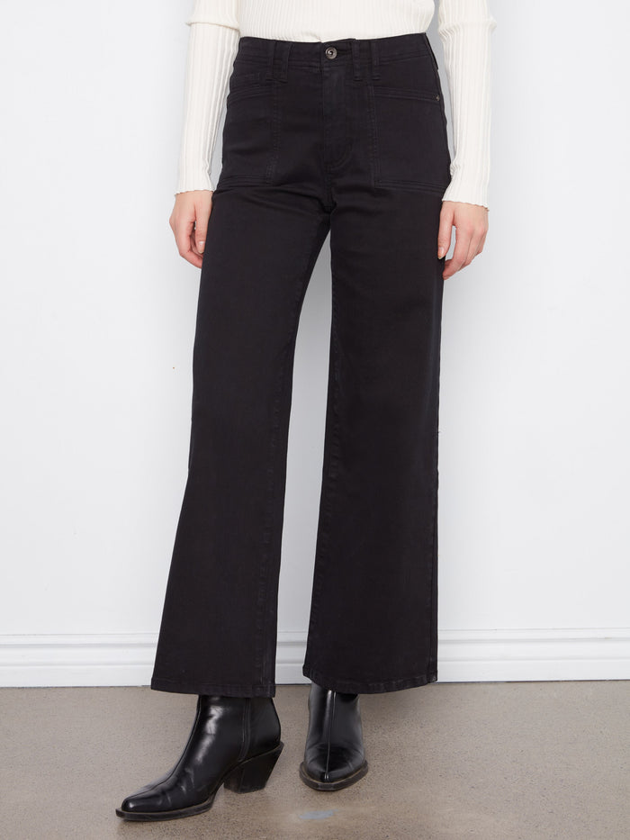 Full-length black twill pants with patch pockets, styled elegantly with black boots by Charlie B.
