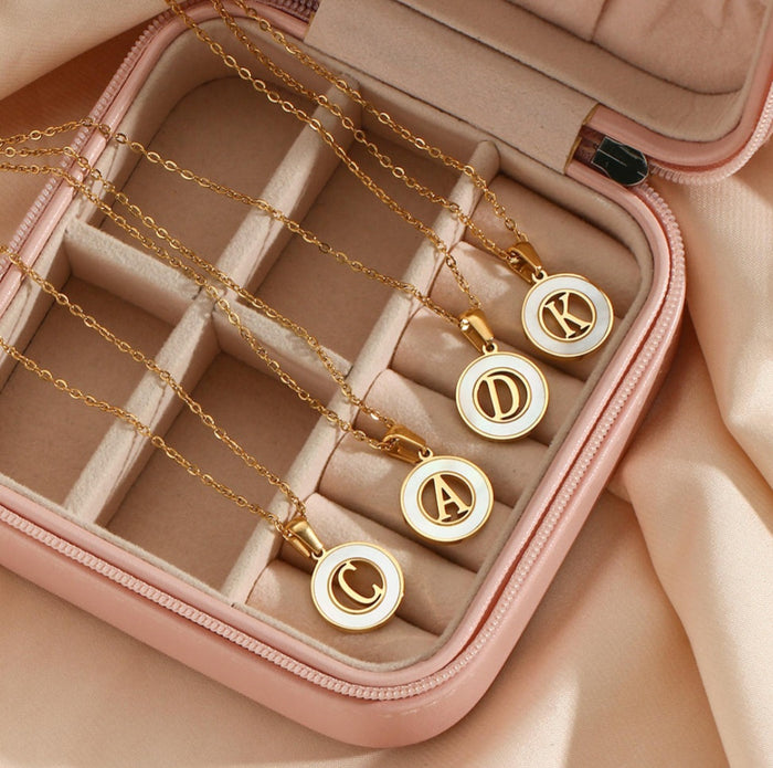 personalized initial necklace featuring gold pendants in an elegant jewelry case.