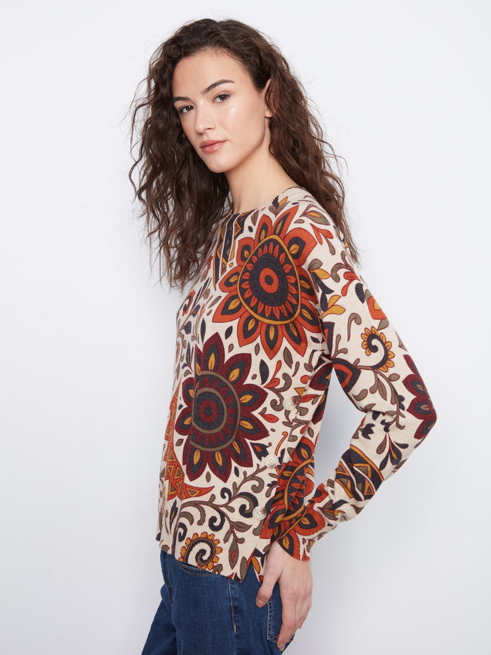 Adorned with side buttons, this floral sweater offers both functionality and flair, making it a versatile wardrobe staple. By Charlie B.