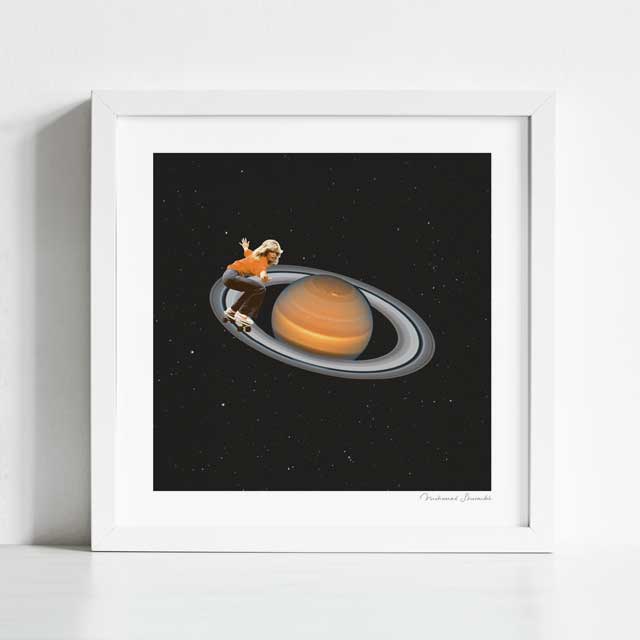 Saturn Skating art print framed view — surreal collage of a skateboarder riding the rings of Saturn against a deep black starry sky, funny cosmic space wall art for creative studios gaming rooms and gallery walls