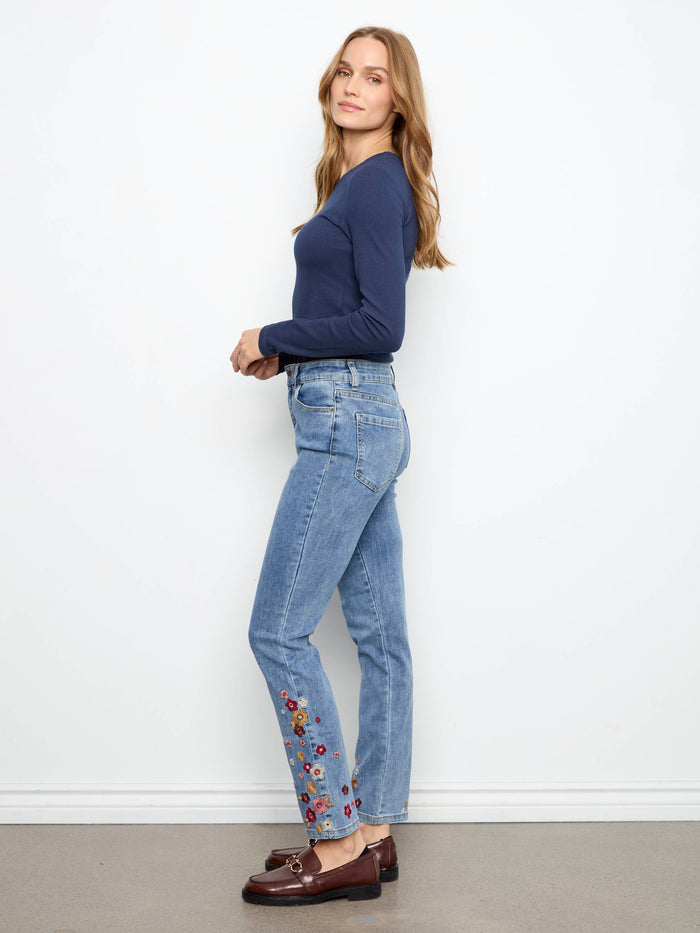 Jeans with ankle length and slim leg design, accented by floral embroidery on the hem by Charlie B.