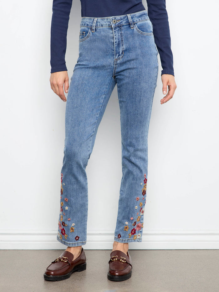 Five-pocket medium blue jeans showcasing intricate floral embroidery on the lower legs by Charlie B.