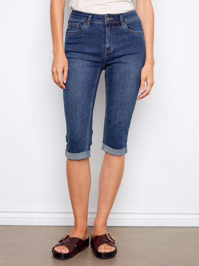 Model showcasing light blue denim capris with a five-pocket design and slim fit by Charlie B.