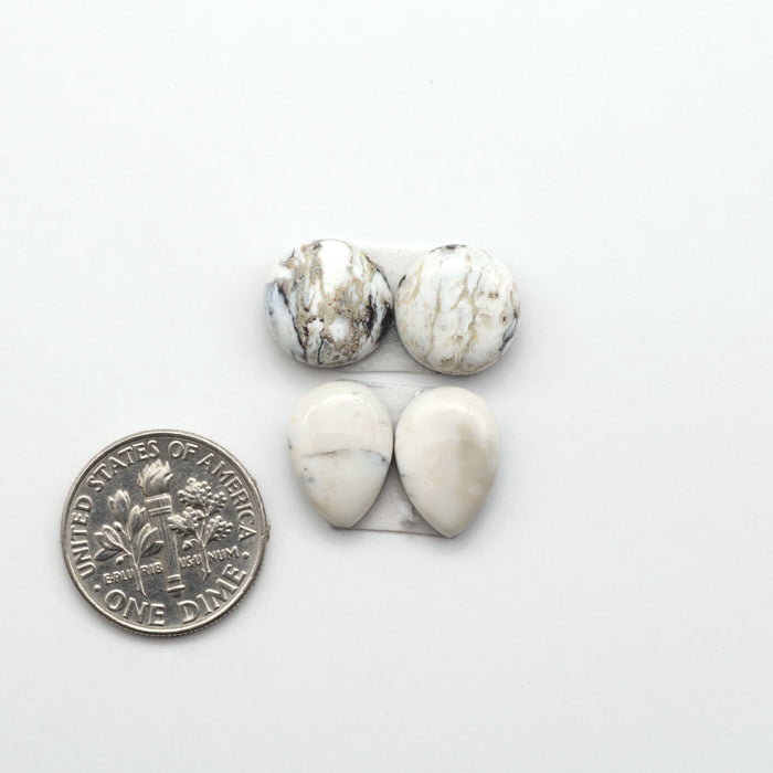 White Buffalo stone cabochons, white stone with black matrix, polished stones on a white background, with a US dime for scale